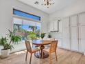 Cozy dining area with a round table, natural light, and views of the beautiful outdoor pool and landscaping at 4935 W Lariat Ln, Phoenix, AZ 85083