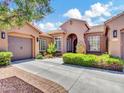 Charming stucco home featuring a tile roof, arched entry, manicured landscaping, and a spacious driveway at 4935 W Lariat Ln, Phoenix, AZ 85083