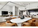 Modern open-concept living area featuring hardwood floors, white seating, contemporary dining set, and stylish decor at 5455 E Lincoln Dr # 3006, Paradise Valley, AZ 85253