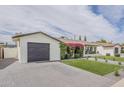 Beautiful home with a grey driveway, a green lawn, and charming landscaping at 8320 E Monte Vista Rd, Scottsdale, AZ 85257