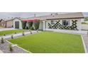 Attractive home exterior with fresh green lawn, bougainvillea, and modern landscaping at 8320 E Monte Vista Rd, Scottsdale, AZ 85257