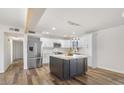 Bright kitchen with white cabinets, stainless appliances, and a striking dark island at 8326 E Crestwood Way, Scottsdale, AZ 85250