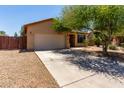 Home exterior showing driveway,desert landscaping, and charming facade under a blue sky at 8541 W Malapai Dr, Peoria, AZ 85345