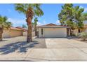 Charming one-story home featuring a two-car garage, desert landscaping, and a large palm tree at 9601 S 44Th St, Phoenix, AZ 85044