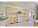 Bright kitchen with wood cabinets, modern appliances, and a window with a view at 11038 W Oraibi Dr, Peoria, AZ 85373
