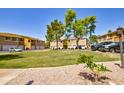 Exterior view of townhomes with green lawn and trees, offering a serene community setting at 1335 E June St # 221, Mesa, AZ 85203