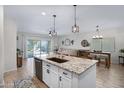 Modern kitchen with an island, stainless steel appliances, granite countertops and an adjacent living area at 1364 W Spine Tree Ave, Queen Creek, AZ 85140