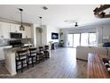 Open concept living room featuring a kitchen island with granite countertops and stainless appliances at 1364 W Spine Tree Ave, Queen Creek, AZ 85140