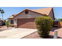 Well-maintained home featuring desert landscaping, a two-car garage, and a clay tile roof at 13862 W Fargo Dr, Surprise, AZ 85374