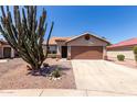 Inviting single-story home with desert landscaping, a two-car garage and cactus at 13862 W Fargo Dr, Surprise, AZ 85374