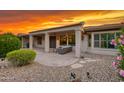 Covered patio with a seating area and desert landscaping providing a tranquil outdoor living space at sunset at 15928 W Zinnia Ct, Surprise, AZ 85374