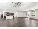 Bright and airy living room featuring wood-style flooring, neutral paint, and a contemporary ceiling fan at 17345 W Spur Dr, Surprise, AZ 85387