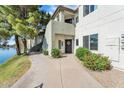 Inviting condo exterior featuring a well-maintained walkway, mature landscaping, and serene waterfront views at 1825 W Ray Rd # 1119, Chandler, AZ 85224