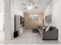 Open-concept living room with neutral tile, white entertainment center, and a comfortable gray sectional couch at 1950 E Kings Ave, Phoenix, AZ 85022