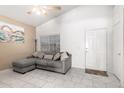 Inviting living room featuring a gray couch, tile floors, neutral decor, and vaulted ceilings at 1950 E Kings Ave, Phoenix, AZ 85022