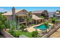 Aerial view of backyard featuring a pool, hot tub, patio, balcony, and palm trees at 19506 N 73Rd Ave, Glendale, AZ 85308