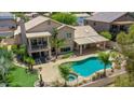 Aerial view of backyard featuring a pool, hot tub, patio, balcony, and palm trees at 19506 N 73Rd Ave, Glendale, AZ 85308