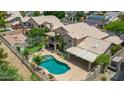 Aerial view of backyard featuring a pool, hot tub, patio, balcony, and palm trees at 19506 N 73Rd Ave, Glendale, AZ 85308