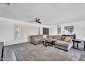 Comfortable living room features a large gray sectional, ceiling fan, and shuttered windows for natural light at 2025 E Magdalena Dr, Tempe, AZ 85283