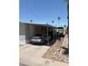 Carport featuring a gray sedan in a well maintained mobile home community at 2060 N Center St # 282, Mesa, AZ 85201