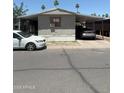 Modest single-story home featuring a covered carport and mature trees in a desert landscape at 2060 N Center St # 282, Mesa, AZ 85201