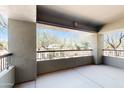 A spacious covered balcony with stone columns and black metal railing overlooks desert landscaping at 21320 N 56Th St # 1158, Phoenix, AZ 85054