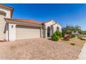 Inviting single-story home features a red-tiled roof, stucco exterior, and a well-manicured front yard with paver driveway at 25601 N 140Th Ln, Surprise, AZ 85387