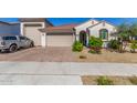 Charming single-story home boasts a red-tiled roof, stucco exterior, and a well-maintained front yard with colorful landscaping at 25601 N 140Th Ln, Surprise, AZ 85387