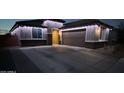 Evening view of a single-story home adorned with festive string lights along the roofline at 25968 W Tina Ln, Buckeye, AZ 85396