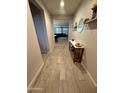 Inviting hallway featuring wood-look tile flooring and stylish decor, leading to the living spaces at 25968 W Tina Ln, Buckeye, AZ 85396