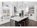 Modern eat-in kitchen with white cabinets, stainless steel appliances, and a large center island at 27562 N 99Th Dr, Peoria, AZ 85383