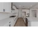 Stylish kitchen featuring white cabinets, quartz countertops, stainless steel appliances, and modern hardware at 40595 W Michaels Dr, Maricopa, AZ 85138