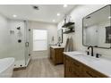 Bright bathroom featuring dual sinks, stand alone tub, glass enclosed shower, and modern fixtures at 4137 W Cielo Grande --, Glendale, AZ 85310