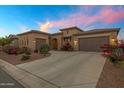 Charming, Southwestern-style home with a well-manicured lawn and a three-car garage at 41584 W Springtime Rd, Maricopa, AZ 85138