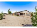 Single-story home exterior with gravel landscaping, a carport, and mature greenery at 5902 W Orange Dr, Glendale, AZ 85301