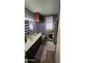 Functional bathroom featuring a single sink vanity, toilet, and a window dressed with a patterned curtain at 604 W Emelita Ave, Mesa, AZ 85210