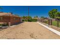 Open backyard with gravel, partial brick wall, and surrounding privacy features, offering a serene outdoor space at 6100 N 36Th Ave, Phoenix, AZ 85019