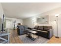Well-lit living room with hardwood floors, comfortable gray sofas, neutral wall color, and a decorative rug and mirror at 7625 E Camelback Rd # B226, Scottsdale, AZ 85251
