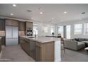 Modern kitchen featuring stainless steel appliances, island with sink, and open floor plan at 7956 W Griswold Rd, Peoria, AZ 85345