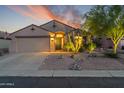 Beautiful home at dusk with illuminated desert landscaping and a charming exterior elevation at 10333 E Gold Nugget Ct, Gold Canyon, AZ 85118