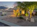 Inviting home at night with warm exterior lighting enhancing the desert landscape and curb appeal at 10333 E Gold Nugget Ct, Gold Canyon, AZ 85118