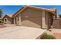 Front exterior showcasing the home's two-car garage and desert landscaping at 11206 W Sieno Pl, Avondale, AZ 85392