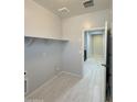 Functional laundry room with built-in shelving, tile floors, and utility connections at 1241 E Palo Verde Dr, Casa Grande, AZ 85122