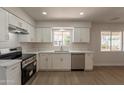 Updated kitchen features modern white cabinets, stainless steel appliances, and new laminate flooring at 1310 E Ironwood Dr, Buckeye, AZ 85326