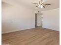 Bright living room features fresh paint, ceiling fan, and new wood-look laminate flooring at 1310 E Ironwood Dr, Buckeye, AZ 85326
