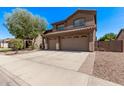 Spacious driveway leads to a home with a three-car garage and well-maintained landscaping at 1405 E Aloe Dr, Chandler, AZ 85286