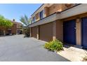 Condo exterior features attached garages, blue front door, and well maintained landscaping at 1411 E Orangewood Ave # 233, Phoenix, AZ 85020