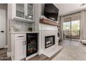 Living room features a fireplace, wine cooler, and modern finishes near sliding doors at 1411 E Orangewood Ave # 233, Phoenix, AZ 85020