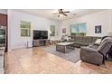 Spacious living room with tile floors, large windows, and ceiling fan at 15862 W Fillmore St, Goodyear, AZ 85338