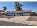 Well-kept home featuring desert landscaping, an arched entryway, and a two-car garage at 1718 W Voltaire Ave, Phoenix, AZ 85029